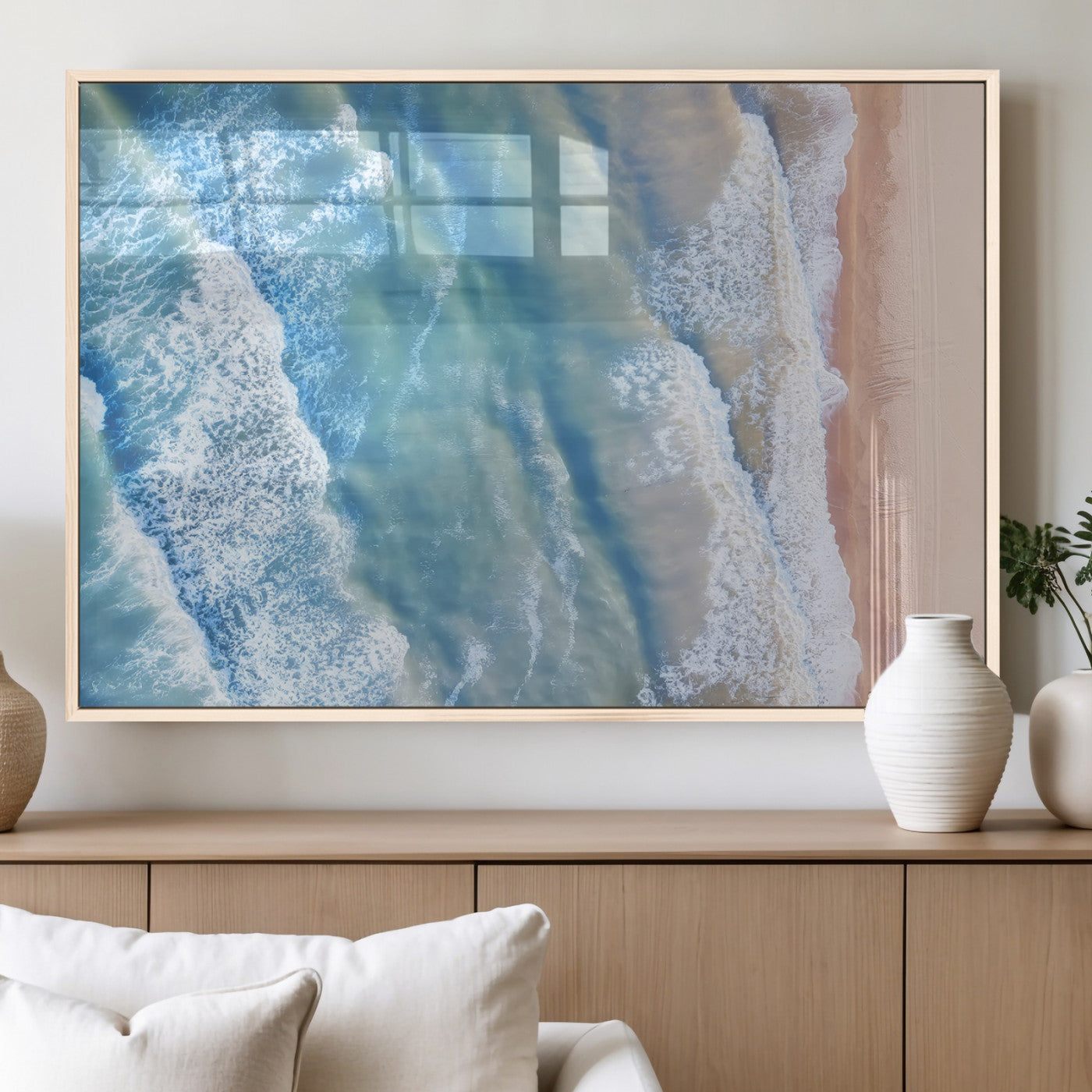 Aerial photo of soft blue waves meeting sandy shore, perfect for modern coastal or beach-themed decor with a light and tranquil aesthetic.