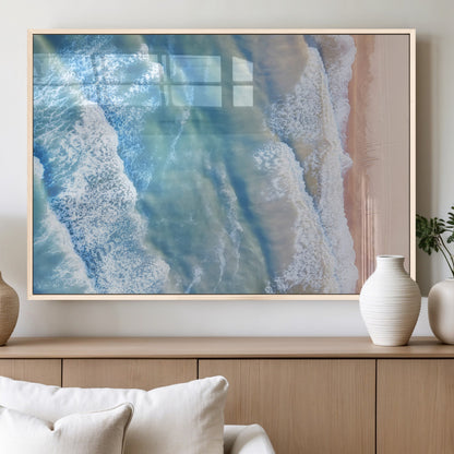 Aerial photo of soft blue waves meeting sandy shore, perfect for modern coastal or beach-themed decor with a light and tranquil aesthetic.