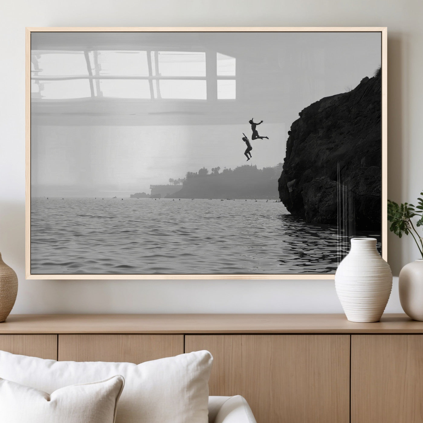 Black and white canvas of two figures cliff jumping into the sea, captured with moody tones, ideal for modern coastal or adventure-themed home decor.   2/2