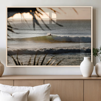 Photo of a surfer riding a golden hour wave at sunset, with tropical tones and dreamy light, perfect for tropical boho or coastal home decor.