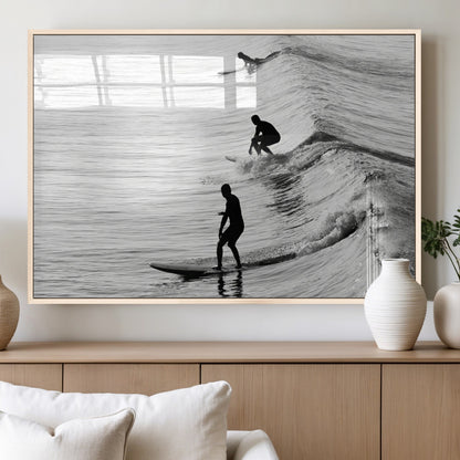 Black and white photo of surfers riding waves in a moody, high-contrast scene, ideal for modern coastal or surf-inspired home decor.