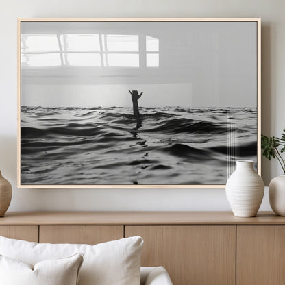 Black and white ocean with a hand making a surfer sign among dark waves, creating a dramatic and minimalist seascape with bold contrast.