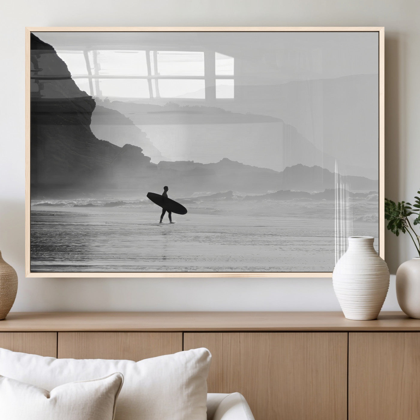 A lone surfer walking along a misty beach with cliffs in the background, carrying their board, capturing a serene and minimal ocean moment.