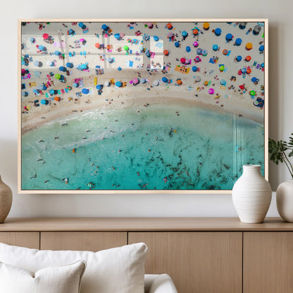 Aerial view of a vibrant beach filled with colorful umbrellas and people enjoying the turquoise ocean, capturing a lively summer vacation scene.