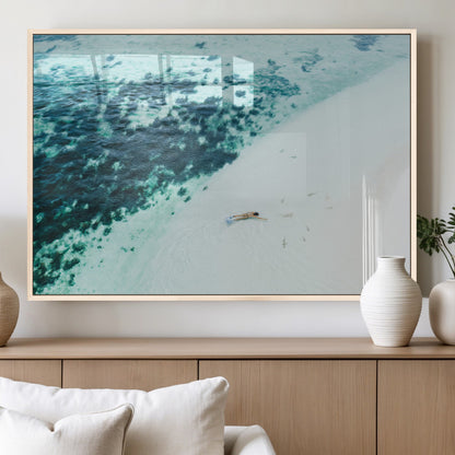 Canvas featuring an aerial view of a swimmer in shallow turquoise waters with coral patterns, ideal for tropical coastal home decor.