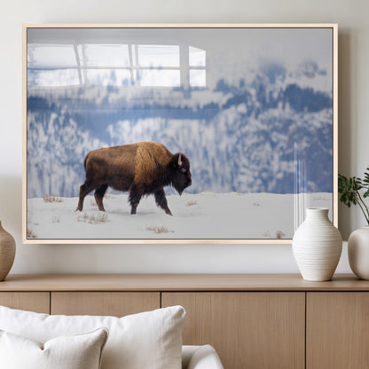 A lone bison walks across snowy ground with blue-toned mountain range behind, ideal for rustic or western farmhouse interiors.