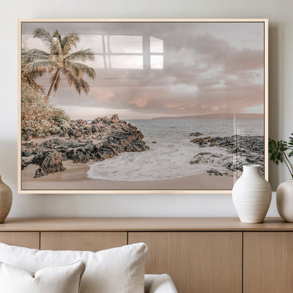 A peaceful beach scene with a palm tree and rocks, soft waves washing onto the shore under a soft pastel sky at sunset.