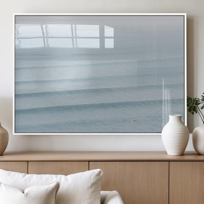 Framed canvas of repeating ocean waves with a distant solo surfer, ideal for minimalist ocean or calm coastal wall decor.