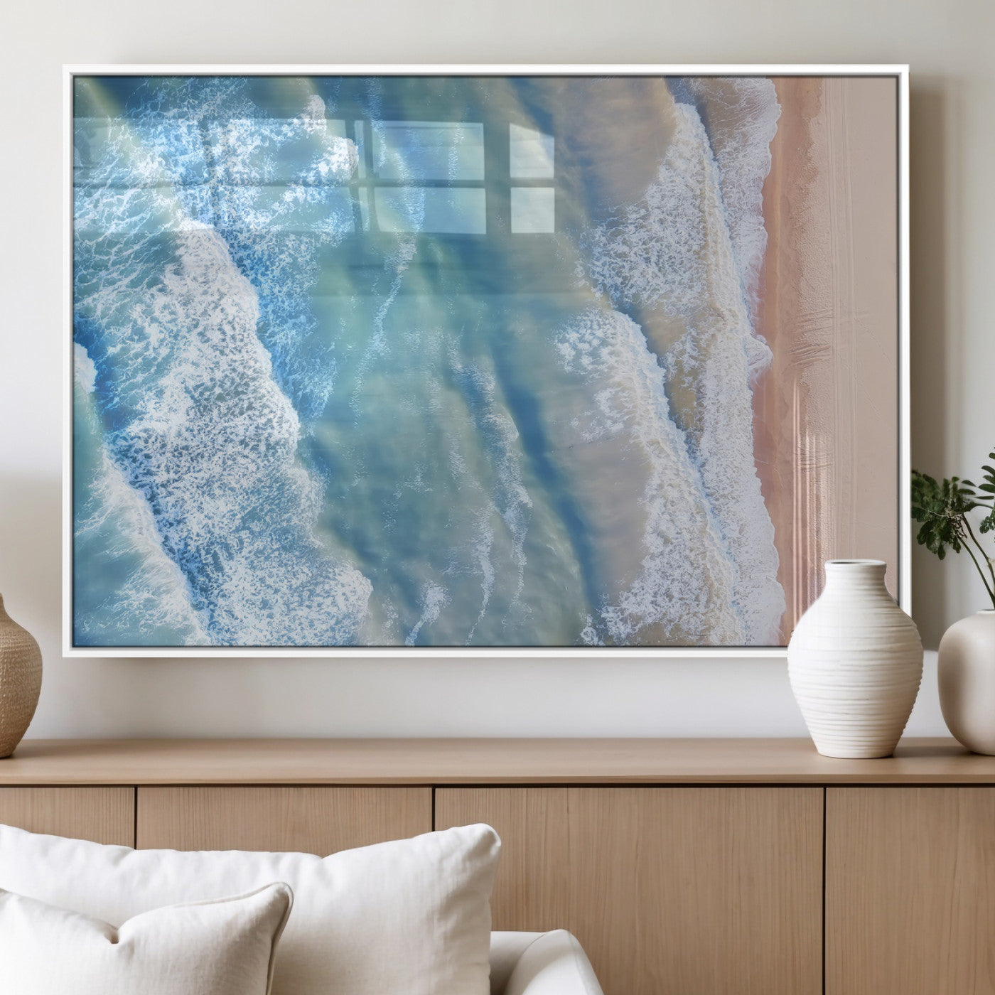 Aerial photo of soft blue waves meeting sandy shore, perfect for modern coastal or beach-themed decor with a light and tranquil aesthetic.