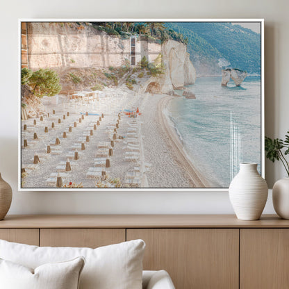 Wall art of a calm Mediterranean beach with rows of sun loungers and umbrellas in soft pastel tones, perfect for light coastal or vacation-themed decor.