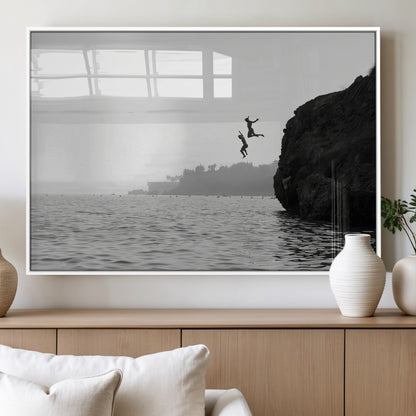 Black and white canvas of two figures cliff jumping into the sea, captured with moody tones, ideal for modern coastal or adventure-themed home decor.   2/2