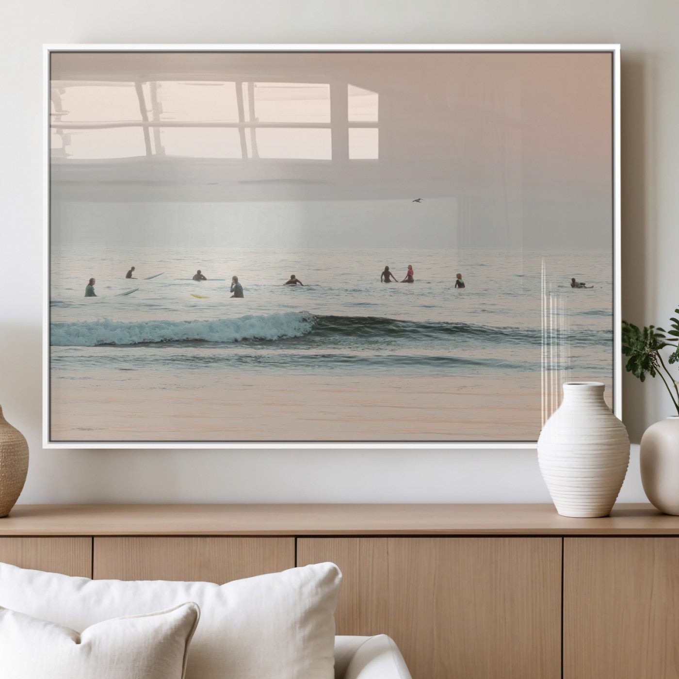 Dreamy photo of surfers waiting on soft pastel waves under a pink sunset sky, ideal for soft coastal minimalist or serene ocean-themed home decor.