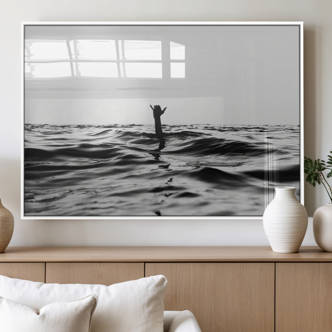 Black and white ocean with a hand making a surfer sign among dark waves, creating a dramatic and minimalist seascape with bold contrast.