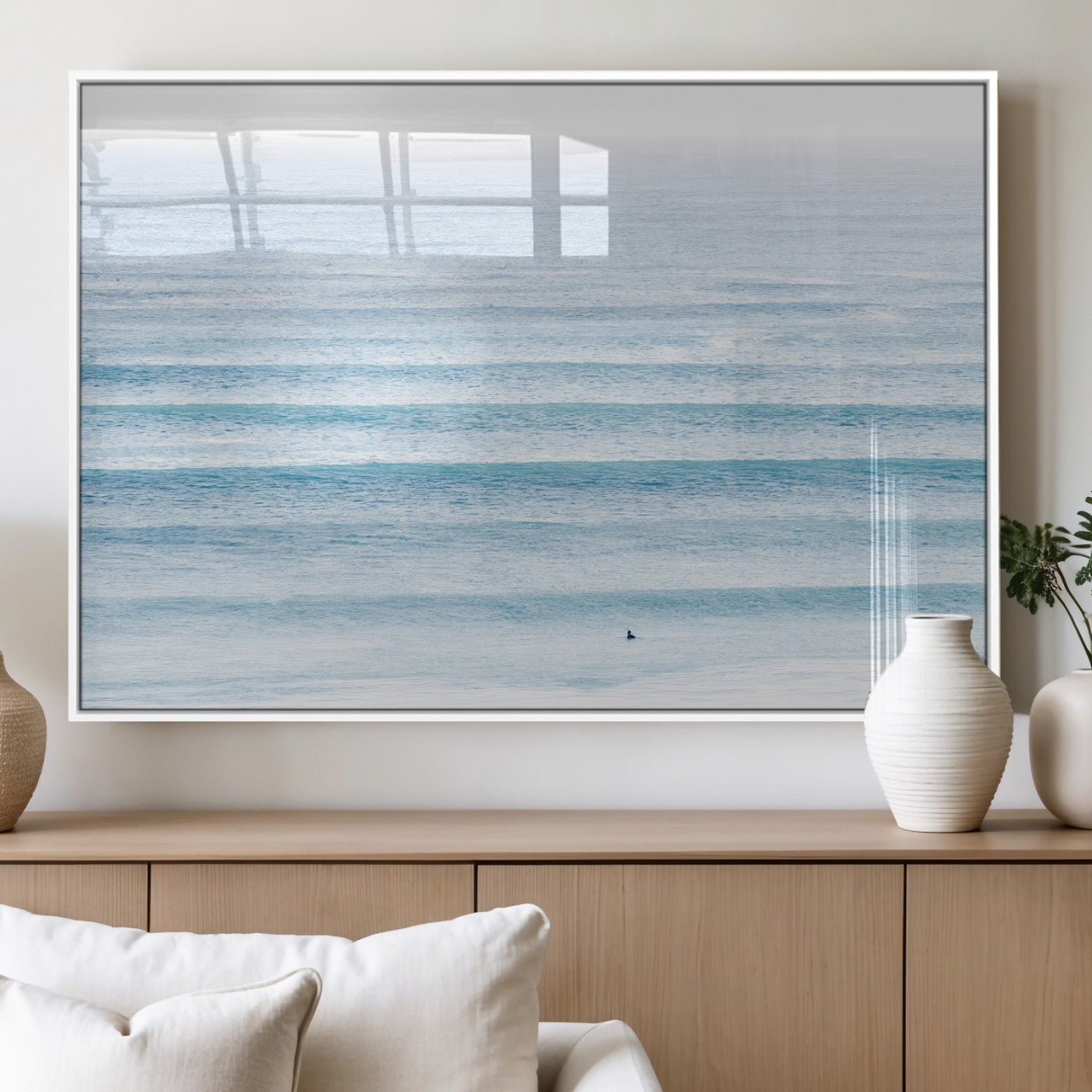 Minimalist ocean view with soft blue waves and a lone surfer, creating a serene and airy coastal aesthetic, perfect for tranquil home decor.