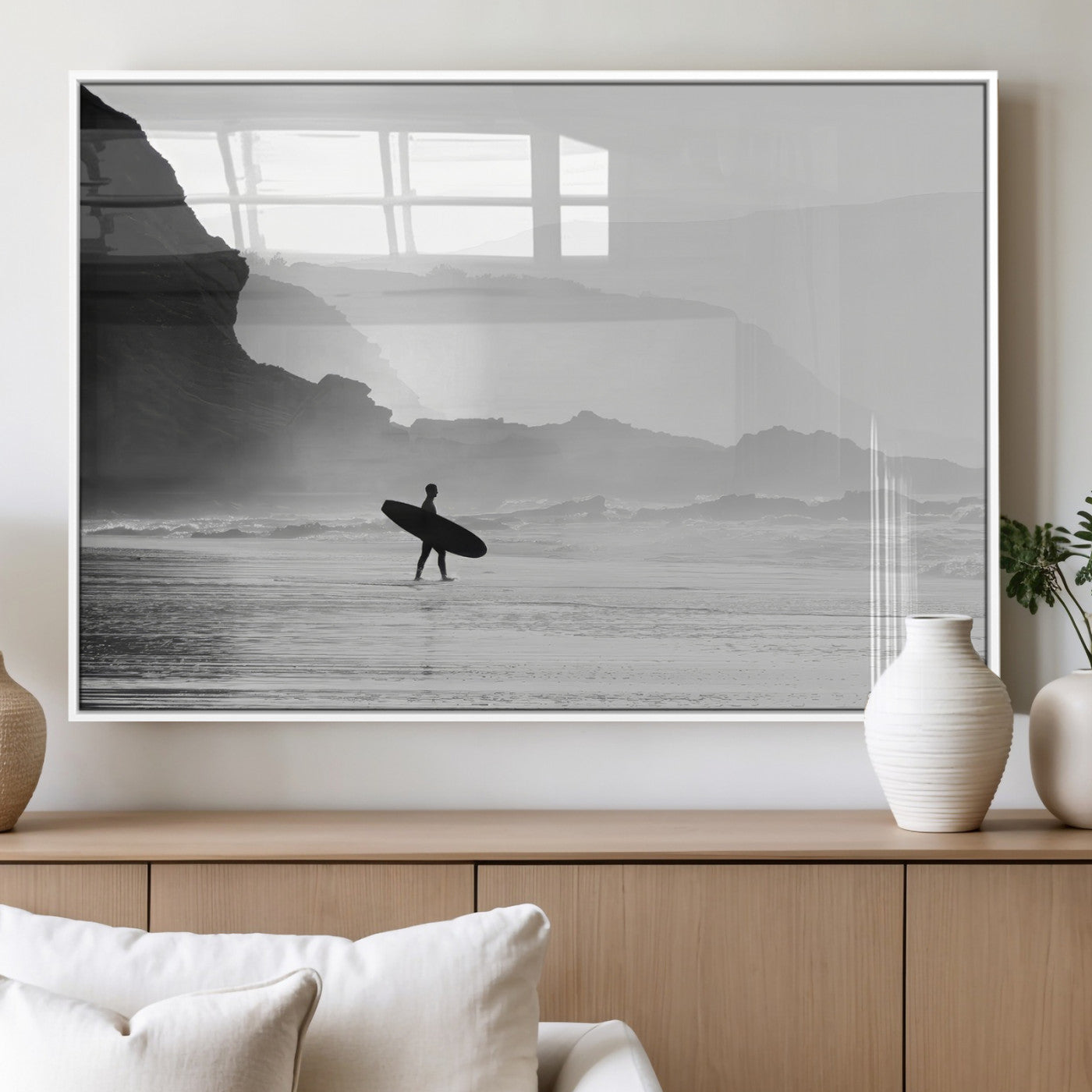 A lone surfer walking along a misty beach with cliffs in the background, carrying their board, capturing a serene and minimal ocean moment.