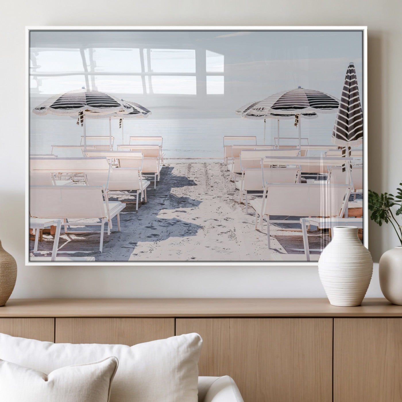 A serene minimalist beach scene featuring striped umbrellas, soft pastel sand, and an elegant lounge setup, creating a tranquil and stylish coastal retreat.