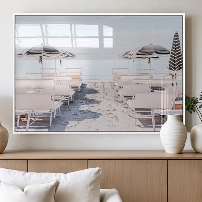 A serene minimalist beach scene featuring striped umbrellas, soft pastel sand, and an elegant lounge setup, creating a tranquil and stylish coastal retreat.