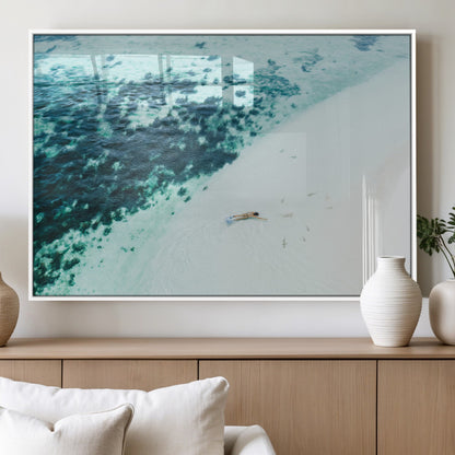 Canvas featuring an aerial view of a swimmer in shallow turquoise waters with coral patterns, ideal for tropical coastal home decor.