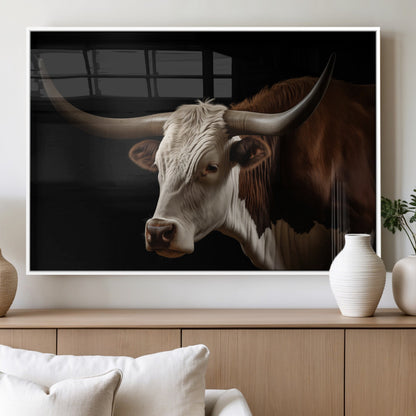 "Close-up of a brown and white longhorn cow with prominent curved horns against a black background."