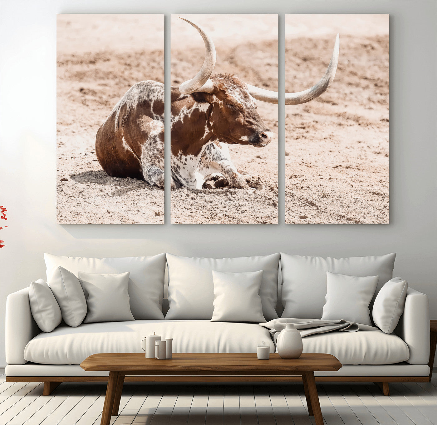 Texas Longhorn bull resting on dusty ground with warm tones, ideal for rustic western or farmhouse-themed wall decor.