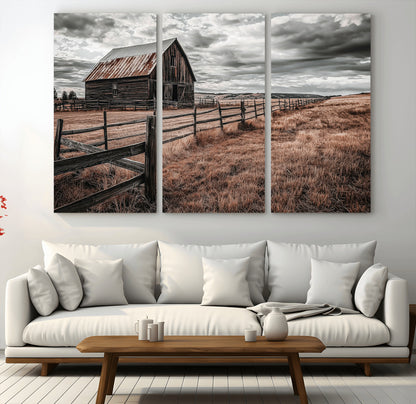 Framed canvas of a rustic barn under a moody sky with weathered fence and dark fields, ideal for farmhouse or rural-style wall decor.