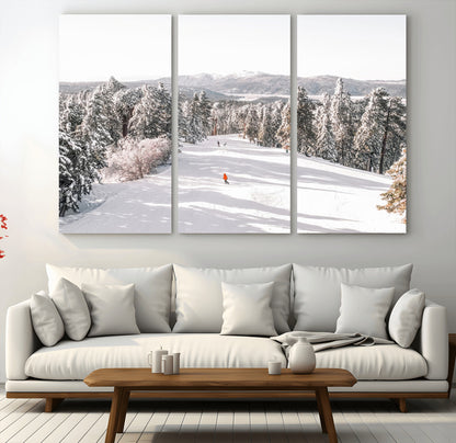 Bright ski trail lined with snow-covered pines and a skier in orange, perfect for alpine adventure or winter sports-inspired decor.