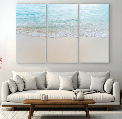 Soft shoreline with gentle aqua waves on smooth sand, ideal for minimalist coastal or pastel ocean-inspired home wall decor.