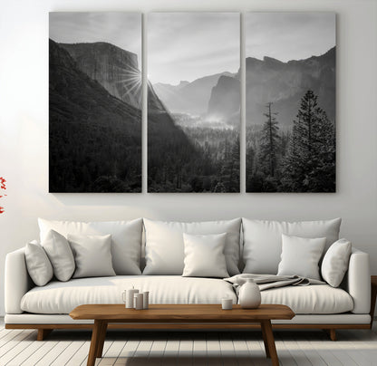 Black and white landscape of Yosemite with sun rays peeking over El Capitan, ideal for moody nature or modern rustic decor.