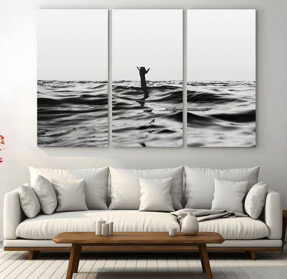 Black and white ocean with a hand making a surfer sign among dark waves, creating a dramatic and minimalist seascape with bold contrast.