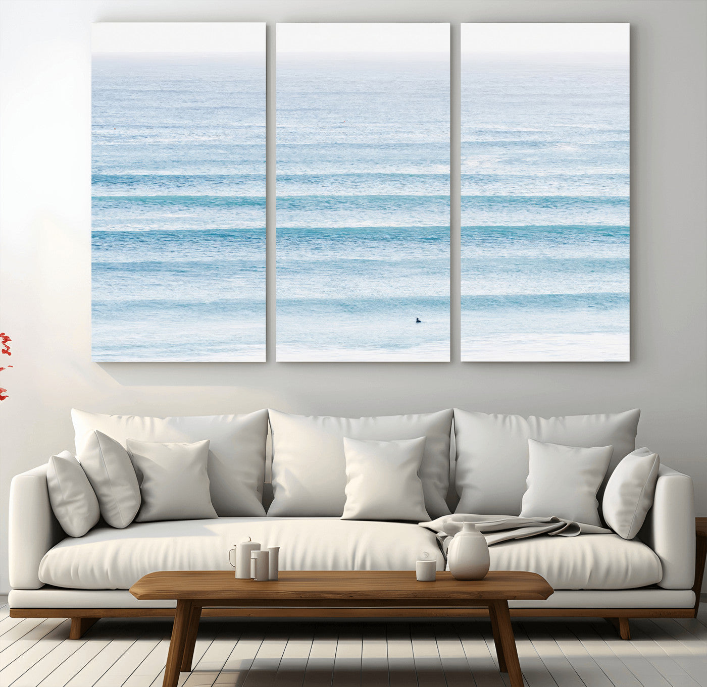 Minimalist ocean view with soft blue waves and a lone surfer, creating a serene and airy coastal aesthetic, perfect for tranquil home decor.