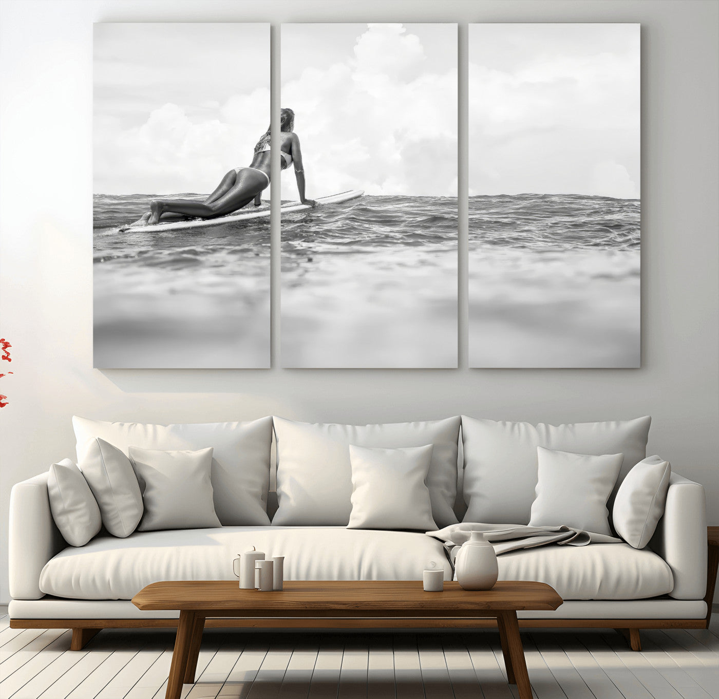A black and white ocean scene featuring a surfer girl waiting on her board, gazing at the horizon, capturing a tranquil and adventurous coastal moment.
