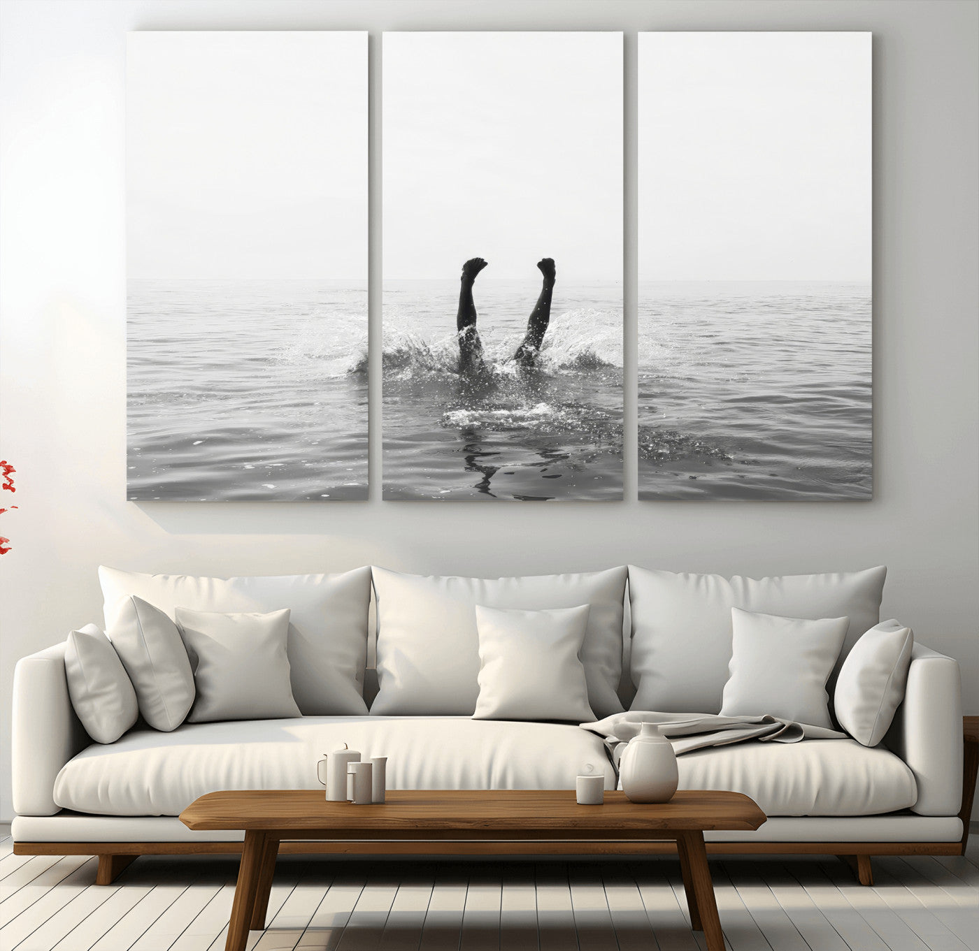 A black and white minimalist water scene capturing a playful splash as a swimmer dives upside down, creating a carefree and artistic aquatic aesthetic.