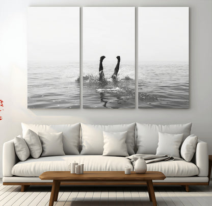 A black and white minimalist water scene capturing a playful splash as a swimmer dives upside down, creating a carefree and artistic aquatic aesthetic.