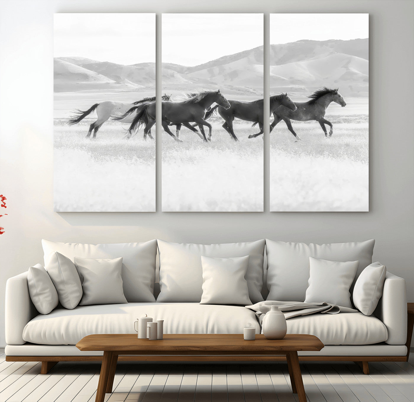 A black and white image of wild horses running freely across an open grassland, capturing the power and beauty of untamed nature in a rustic western setting.