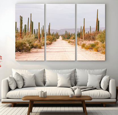 A desert road lined with saguaro cacti under a golden sky, creating a warm southwestern feel, perfect for boho or rustic decor.