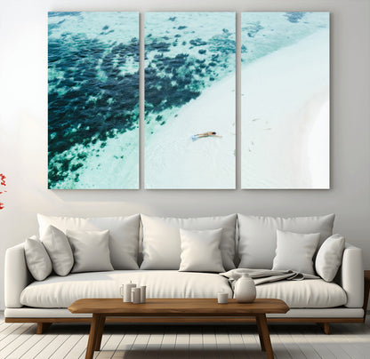 Canvas featuring an aerial view of a swimmer in shallow turquoise waters with coral patterns, ideal for tropical coastal home decor.