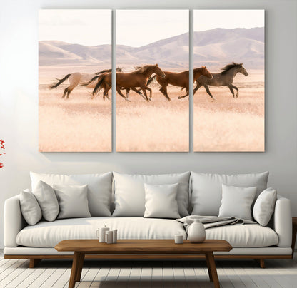 A herd of wild horses galloping through a sunlit desert plain with mountains in the background, perfect for rustic or western-themed wall decor.