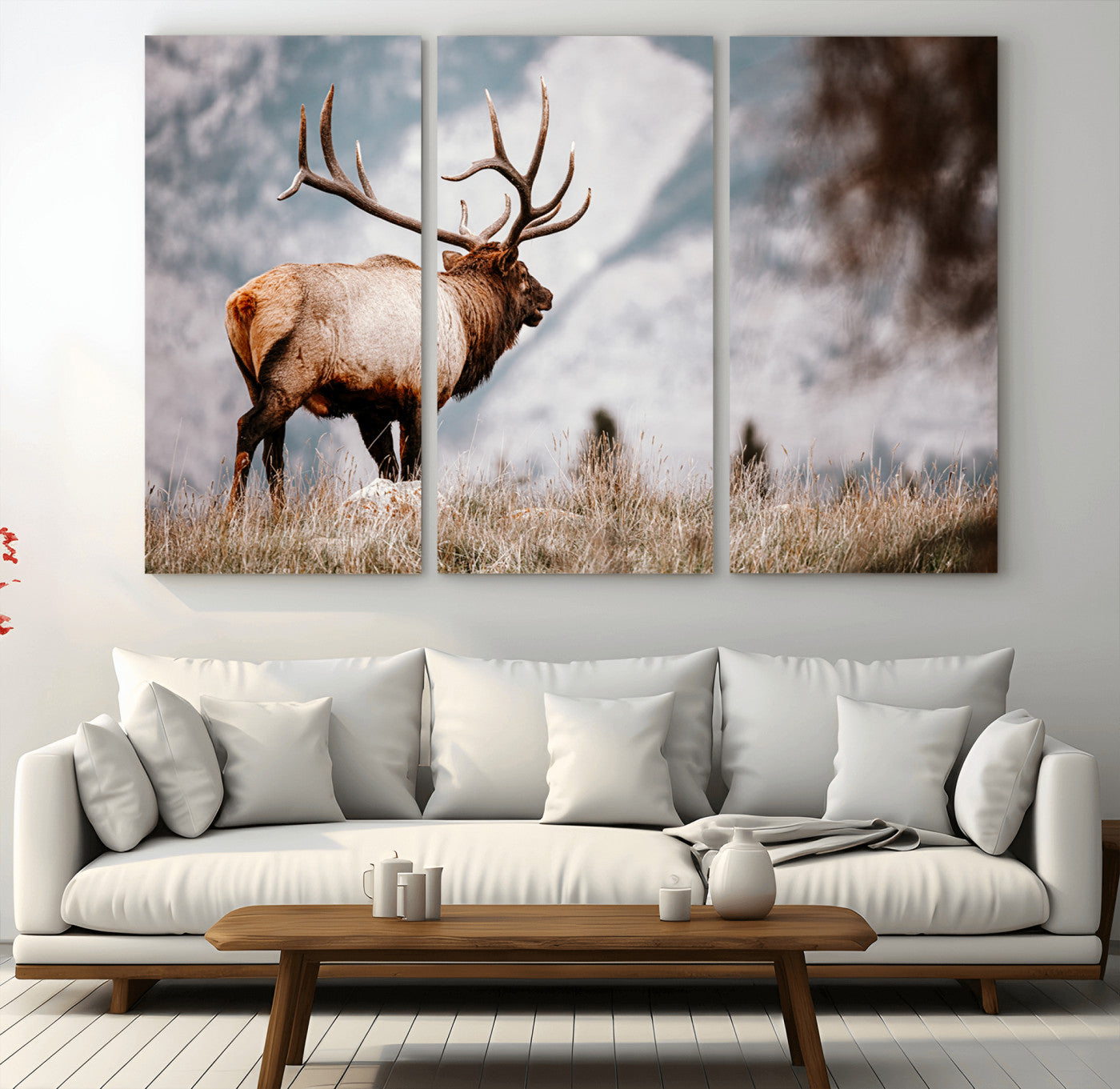 Majestic elk with large antlers standing in grass with snowy mountains in background, perfect for rustic cabin or lodge style decor.