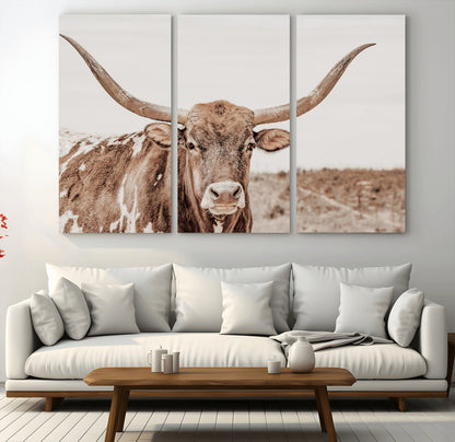 A longhorn cow in soft beige desert tones, standing calmly in open land, perfect for neutral western or rustic farmhouse interiors.