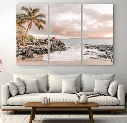 A peaceful beach scene with a palm tree and rocks, soft waves washing onto the shore under a soft pastel sky at sunset.