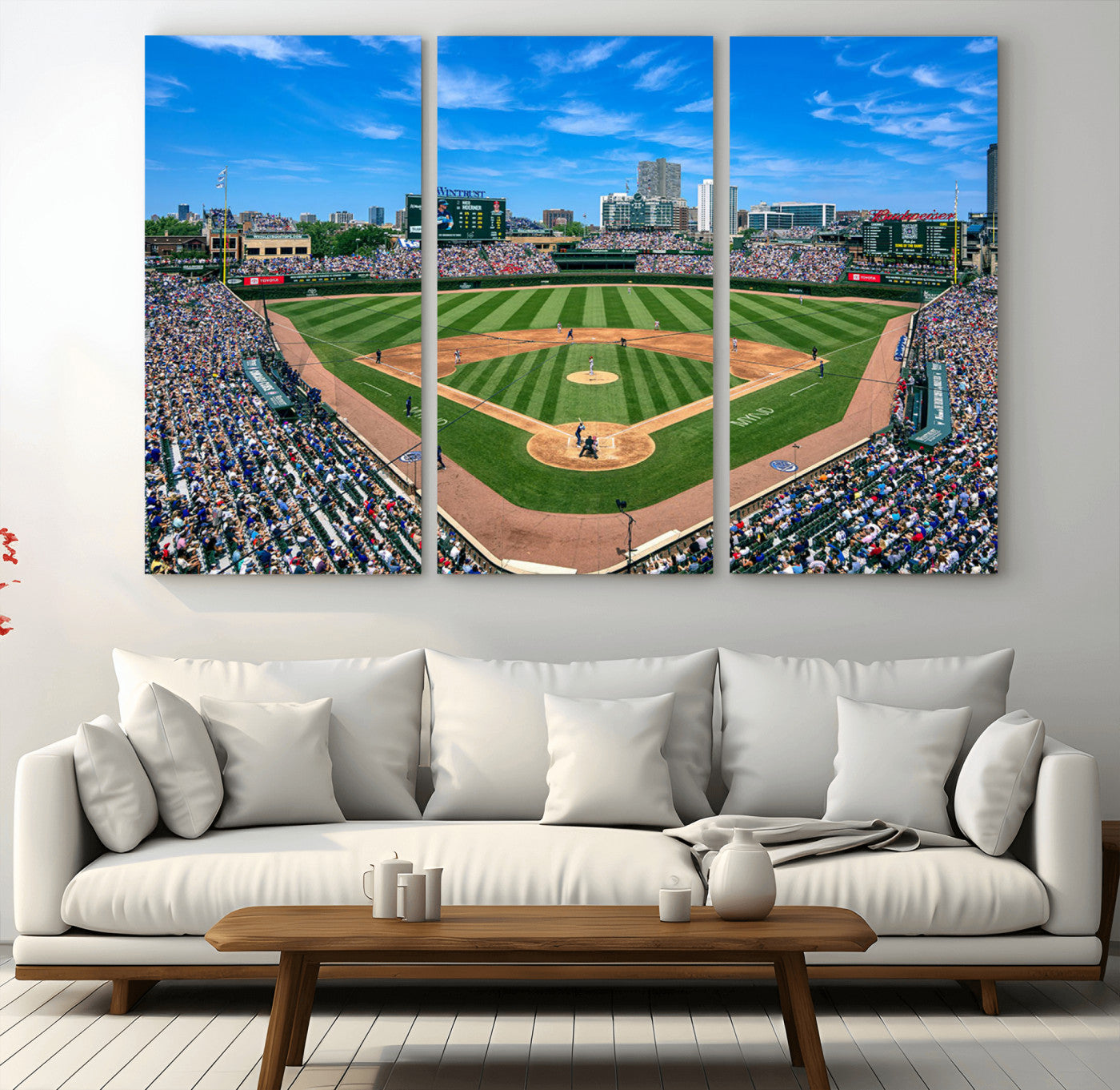 A wide-angle shot of a baseball field filled with spectators, with players on the field and the iconic Wrigley Field scoreboard in the background.