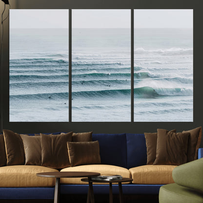 High-angle view of surfers lining up across layered ocean waves, ideal for minimal coastal or surf-inspired room decor.