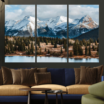 Framed canvas of snowy mountain peaks with pine forest and alpine lake, perfect for winter cabin or wilderness-inspired home decor.