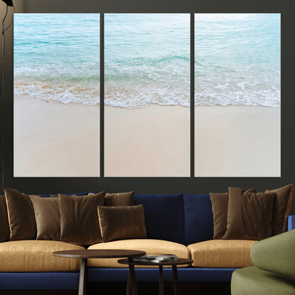 Soft shoreline with gentle aqua waves on smooth sand, ideal for minimalist coastal or pastel ocean-inspired home wall decor.