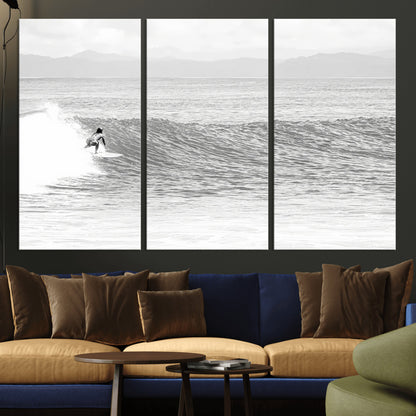 Monochrome photo of a surfer riding a wave with distant mountains, ideal for coastal motion or black and white surf-themed wall decor.