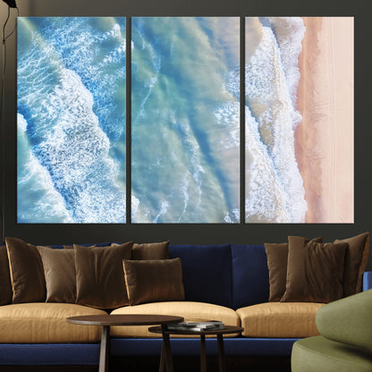Aerial photo of soft blue waves meeting sandy shore, perfect for modern coastal or beach-themed decor with a light and tranquil aesthetic.