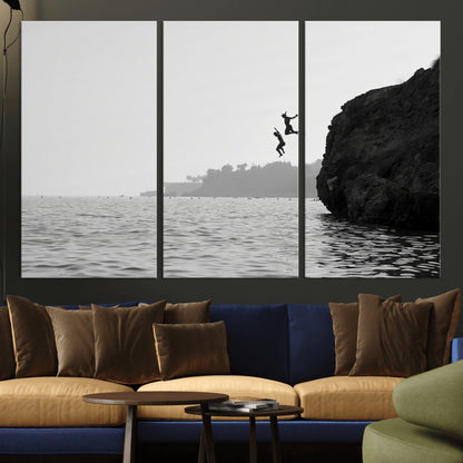 Black and white canvas of two figures cliff jumping into the sea, captured with moody tones, ideal for modern coastal or adventure-themed home decor.   2/2