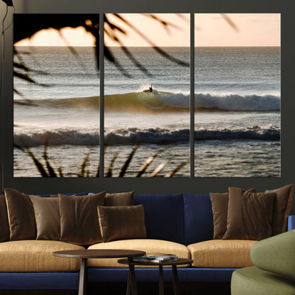 Photo of a surfer riding a golden hour wave at sunset, with tropical tones and dreamy light, perfect for tropical boho or coastal home decor.