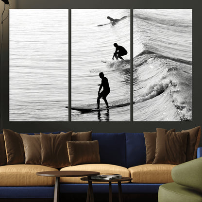 Black and white photo of surfers riding waves in a moody, high-contrast scene, ideal for modern coastal or surf-inspired home decor.