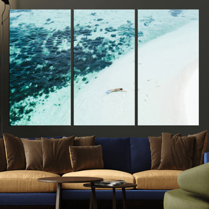 Canvas featuring an aerial view of a swimmer in shallow turquoise waters with coral patterns, ideal for tropical coastal home decor.